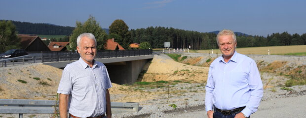 Vor der 2020 fertiggestellten Brücke an der B85 bei Ayrhof informierte Bauamtsdirektor Robert Wufka (l.) MdB Alois Rainer über den weiteren Fortgang der Arbeiten zum Ausbau der Bundes-straße: Nächste Woche geht es mit den Arbeiten für den Bau des dritten Fahrstreifens los.