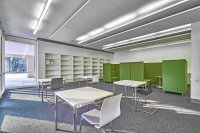 Blick in die südliche Raumzone des neuen Lernraums in der Uni-Zentralbibliothek mit insgesamt 52 Arbeitsplätzen. Zwei grüne Lernkojen bilden einen Rückzugsort für Besucherinnen und Besucher.
