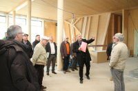 Auf der Baustelle für das Nawareum erklärte Ltd. Baudirektor Norbert Sterl den Besuchern um den VSVI-Bezirksgruppenvorsitzenden Dipl.-Ing. Robert Wufka, wie das Gebäude mit Holz ausgebaut wird.