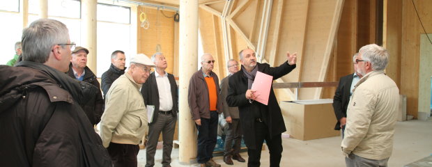 Auf der Baustelle für das Nawareum erklärte Ltd. Baudirektor Norbert Sterl den Besuchern um den VSVI-Bezirksgruppenvorsitzenden Dipl.-Ing. Robert Wufka, wie das Gebäude mit Holz ausgebaut wird.