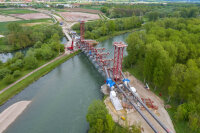 Nachdem sich der Fahrbahnrost bzw. die Fahrbahnträger aus beiden Richtungen etwa in der Flussmitte geschlossen hatten, begann die Konstruktion der Stahlbögen. Dabei kamen Hilfsjoche, stehend auf den nach wie vor abgespannten Querträgern, zum Einsatz, auf die die Bogensegmente zur Flussmitte hin aufgelegt wurden. Nachdem sich der Fahrbahnrost bzw. die Fahrbahnträger aus beiden Richtungen etwa in der Flussmitte geschlossen hatten, begann die Konstruktion der Stahlbögen. Dabei kamen Hilfsjoche, stehend auf den nach wie vor abgespannten Querträgern, zum Einsatz, auf die die Bogensegmente zur Flussmitte hin aufgelegt wurden.