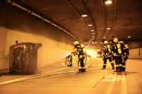 In der Mitte der Tunnelröhre lag das brennende „Unfallauto“, das die Feuerwehrleute zunächst lö-schen mussten.