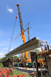 Zentimetergenau müssen die Arbeiter die tonnenschweren, 24 Meter langen Spannbeton-Fertigteile auf den Widerlagern einpassen. 