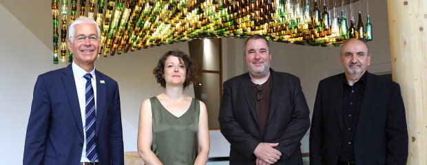 Die „Welle“ aus 900 Altglasflaschen ist fertig – das Kunstwerk von Künstler Tom Kristen (2.v.r.) empfängt als Blickfang im Foyer die Besucher des NAWAREUM. Zur Fertigstellung trafen sich Norbert Sterl, der Leiter des Staatlichen Bauamts Passau (r.), Dr. Bernhard Widmann (v.l.), der Leiter des Technologie- und Förderzentrums Straubing, und Dr. Vanessa Roden, Direktorin des NAWAREUM, mit dem Künstler. Die „Welle“ aus 900 Altglasflaschen ist fertig – das Kunstwerk von Künstler Tom Kristen (2.v.r.) empfängt als Blickfang im Foyer die Besucher des NAWAREUM. Zur Fertigstellung trafen sich Norbert Sterl, der Leiter des Staatlichen Bauamts Passau (r.), Dr. Bernhard Widmann (v.l.), der Leiter des Technologie- und Förderzentrums Straubing, und Dr. Vanessa Roden, Direktorin des NAWAREUM, mit dem Künstler.