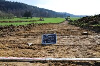 Eine Tafel kennzeichnet die Grabung: Auf etwa 20 Prozent der Fläche trugen die Baggerfahrer den Oberboden ab, damit der Archäologe die darunterliegenden Schichten begutachten konnte.