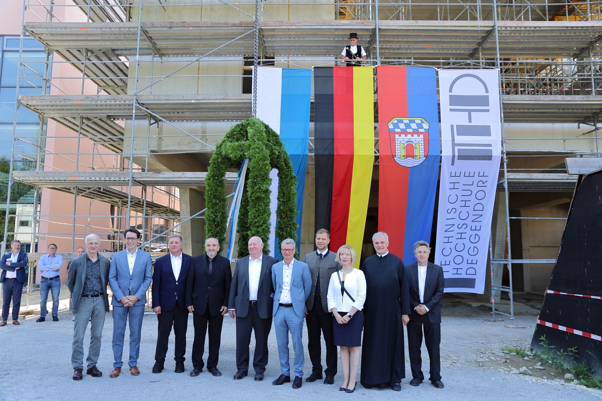 Beim Richtfest: (v.l.) Heiner Sendelbach, Gesellschafter der Schneider + Sendelbach Architekten-GmbH, Oberbürgermeister Dr. Christian Moser, Staatsminister Christian Bernreiter, Leitender Baudirektor Norbert Sterl, Leiter des Staatlichen Bauamts Passau, Vizepräsident und designierter Präsident der Technischen Hochschule Deggendorf Prof. Waldemar Berg, Landrat Bernd Sibler, Bezirkstagspräsident Olaf Heinrich, Geschäftsführerin des Studentenwerks Niederbayern/Oberpfalz Doreen Steudte, Abt Wolfgang Hagl emeritus und Baudirektor Gerald Escherich, im Hintergrund Siegfried Piske, Obermeister der Zimmererinnung Passau, der den Richtspruch gehalten hatte. Beim Richtfest: (v.l.) Heiner Sendelbach, Gesellschafter der Schneider + Sendelbach Architekten-GmbH, Oberbürgermeister Dr. Christian Moser, Staatsminister Christian Bernreiter, Leitender Baudirektor Norbert Sterl, Leiter des Staatlichen Bauamts Passau, Vizepräsident und designierter Präsident der Technischen Hochschule Deggendorf Prof. Waldemar Berg, Landrat Bernd Sibler, Bezirkstagspräsident Olaf Heinrich, Geschäftsführerin des Studentenwerks Niederbayern/Oberpfalz Doreen Steudte, Abt Wolfgang Hagl emeritus und Baudirektor Gerald Escherich, im Hintergrund Siegfried Piske, Obermeister der Zimmererinnung Passau, der den Richtspruch gehalten hatte.