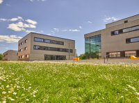Das Transferzentrum Technik und Innovation (Mitte) komplettiert als fünftes Gebäude das Ausbauprogramm auf dem Erweiterungsgelände der Technischen Hochschule Deggendorf. Den Neubau flankieren links ein Hörsaalgebäude und rechts das Institutgebäude der Medientechnik.